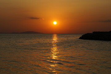 Obraz premium Golden sunset over the sea with sun reflection on wavy seawater