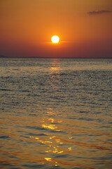 Obraz premium Evening sunlight reflecting on the calming sea