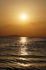 Fototapeta premium Minimal seascape with golden sunlight reflection on the seawaves