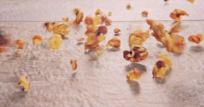 Front view of low speed falling walnuts on a natural surface.