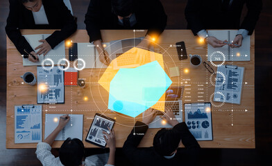 A high-angle view of a team collaborating on data analysis, featuring charts, graphs, and digital overlays, emphasizing teamwork and modern business strategies. Trope