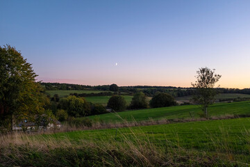 Sun shining in a sunset beautiful landscape in the green fields and meadows in the Cotswolds England