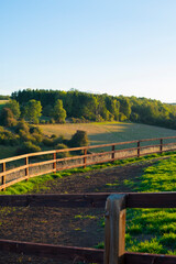 Rural sunset landscape in the Cotswolds with a wooden farm fence
