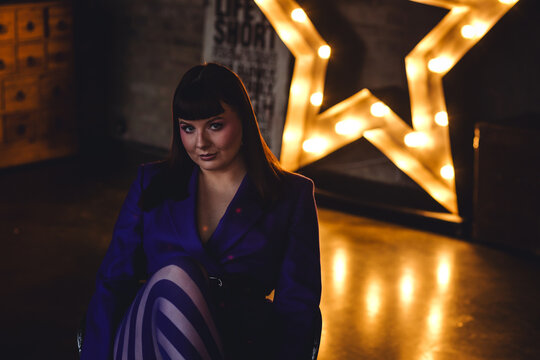 Elegant mature woman in a blue suit and tights. Gorgeous beautiful attractive plus size young woman with long hair. Body positive concept. Happy smiling single female