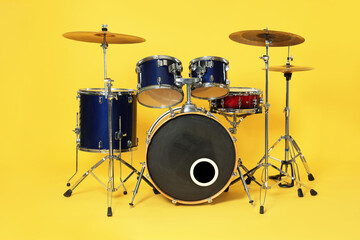 Modern drum kit on yellow background. Musical instrument