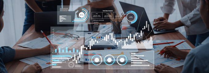 A diverse business team engages in collaborative data analysis, using digital graphs and charts to drive informed decision-making in a modern office setting. Trope