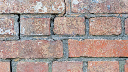Obraz premium red old brick wall background, brick wall texture, structure. old broken brick, cement joints, close-up. crumbling from old age. macro photo. construction, repair. concept of devastation, decline