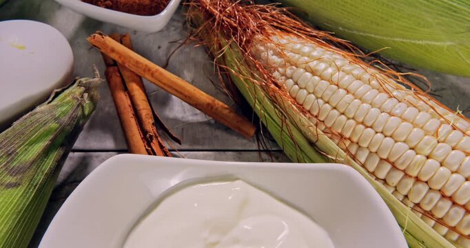Overhead view, tour view of corn pie with ingredients on a natural surface.