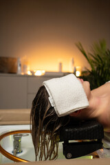 Woman enjoying relaxing hair washing and scalp care treatment in a spa salon with warm ambient lighting.
