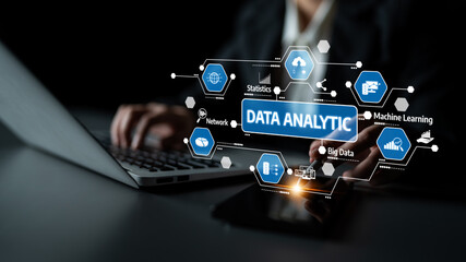 A professional analyzes data using a laptop and smartphone, showcasing data analytics elements through virtual graphics on a dark background in an office setting. Tessel