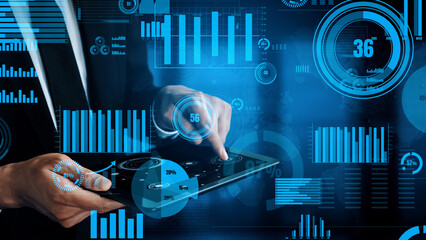 A business professional analyzes key data insights on a tablet, surrounded by intricate digital graphs and statistics, showcasing modern analytics in action. Xenic