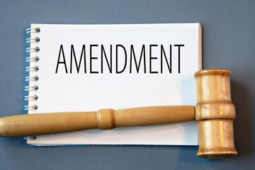 AMENDMENT - word in a white notebook on a gray background with a judge's gavel