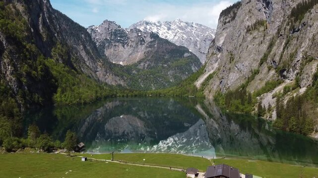 Cinematic reflection of rugged alpine mountains in crstal clear Lake Obersee aeial shot