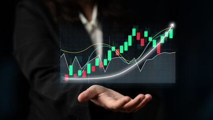 A business professional displays a digital stock market chart featuring candlestick patterns and growth indicators against a contrasting dark backdrop. Impute