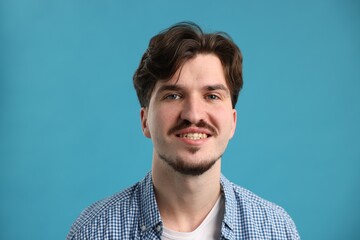 Obraz premium Handsome man with mustache on light blue background