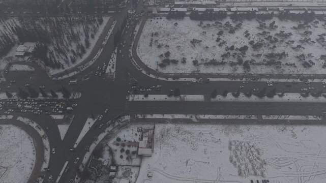 A drone shot of Aleppo, Syria, during a heavy snowstorm shows urban architecture and streets covered in white. Cinematic winter scenery in a Middle Eastern urban environment.
