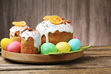 Obraz premium Delicious decorated Easter cakes and eggs on wooden table