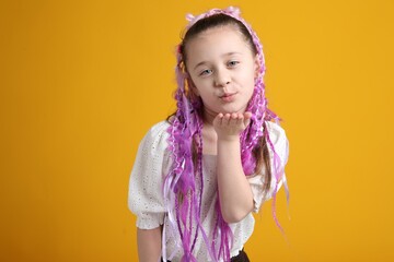 Cute girl with stylish hairstyle on yellow background