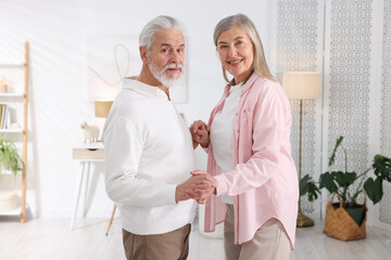 Fototapeta premium Lovely senior couple dancing together at home