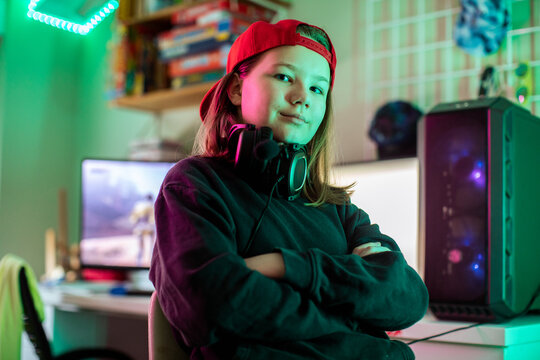 Confident teen gamer with headset at home gaming pc setup