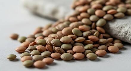 Fototapeta premium A close-up view of a pile of raw, dried brown and green lentils, a healthy and versatile legume ingredient for various culinary dishes and wholesome meals
