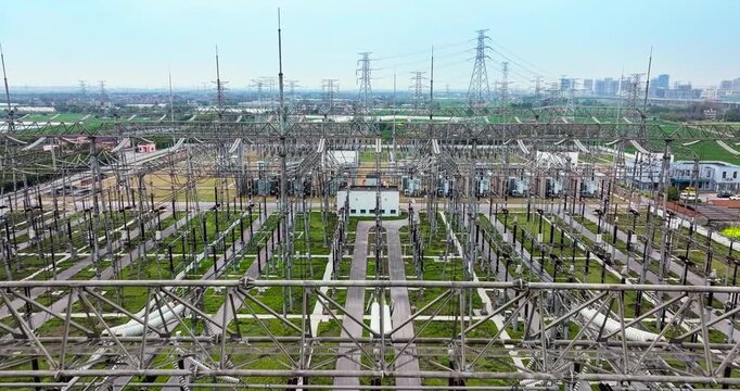Large industrial electrical substation distributing power in an urban area during the day.