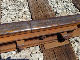 A closeup of a railroad track. Including the rail, a tie, a joint, and ballast