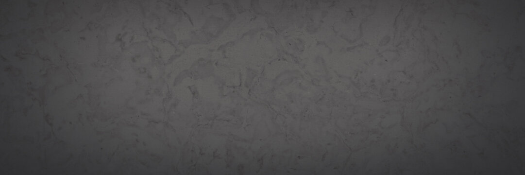 Dark wide panoramic background. Natural rock with patterns on the surface. Dolomite texture. Solid stone background for design. Shaded faded texture with vignette.