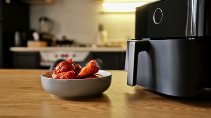 Delicious chicken wings coated in a rich red sauce ready for air frying