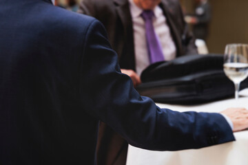 Fototapeta premium Group of men in business suits talking and discussing during coffee break at conference, politicians and entrepreneurs networking and negotiate, businessmen have dialog conversation, decision making