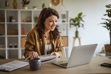 Woman working remotely during video call using headset