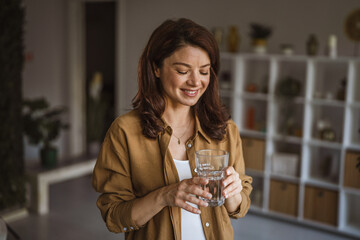 Woman enjoying glass of water promoting hydration and well being