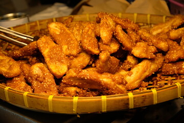 Crispy fried bananas coated in sesame seeds served in a traditional woven basket © Thanakrit