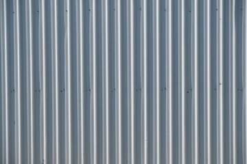 Obraz premium Corrugated metal siding with vertical ridges and subtle texture, a neutral background.