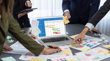 Analyst team use sticky note for creative and analytic brainstorm for business idea with BI data dashboard on laptop screen. Analysis financial data visualization tech for marketing strategy. Prodigy