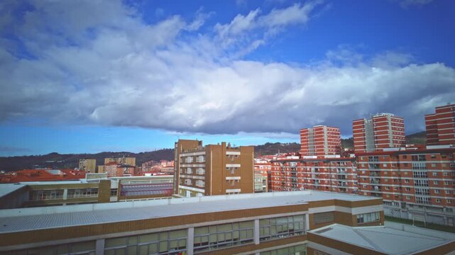 Timelapse shot of clouds moving over bilbao city skyline