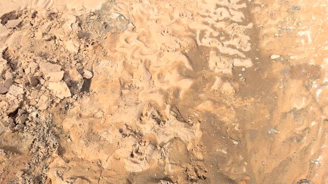Pan up reveal shot of large culvert for rain runoff constructed of cement and stone in rock wall in desert
