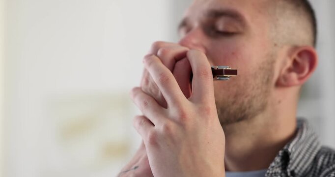 Man playing harmonica at home. Musical instrument