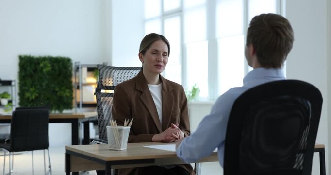 Smiling recruiter and candidate having job interview at table in office
