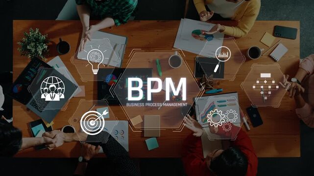 A high-angle view captures a collaborative team in a modern workspace, focused on business process management, utilizing digital tools and innovative strategies. Raster