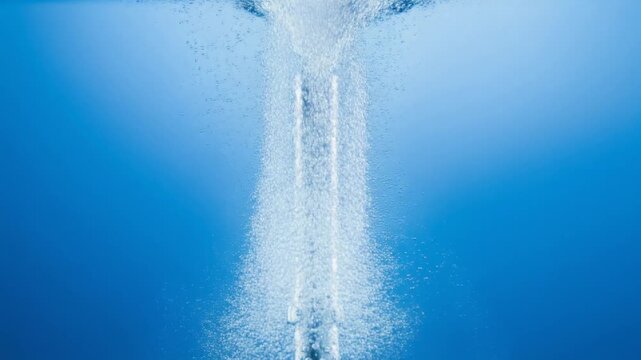 Underwater macro of thousands of tiny bubbles rising from metal surface, continuous stream