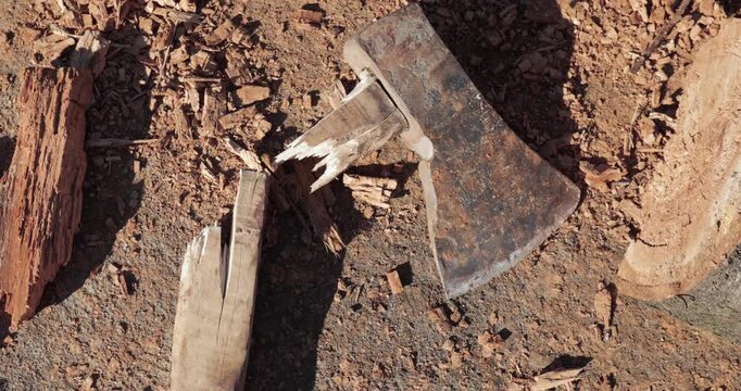 Broken ax on the ground by the woodstack