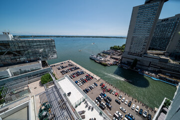 Obraz premium Elevated view of the toronto harbourfront, showing modern buildings, boats docked in the marina, and a wide expanse of lake ontario under a clear blue sky