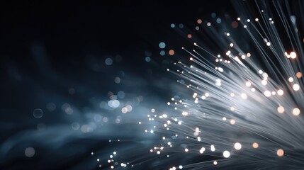Obraz premium Bundle of glowing fiber optic cables emitting blue and amber points of light with bokeh