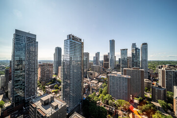 Fototapeta premium Urban skyline presenting numerous high rise residential and commercial buildings under a clear blue sky, illustrating city development and modern architecture