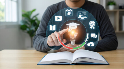 Person touches glowing lightbulb with graduation cap and online learning icons above open book for digital education