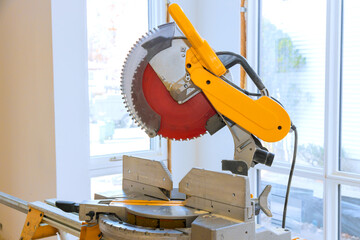 Table saw sits in saw has circular blade ready for cutting wood, tools materials surround area busy work environment.