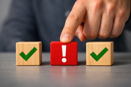 A Decision Point: A hand selects the red block among the green checked blocks on the blurred background, highlighting a crucial decision or a potential hazard.