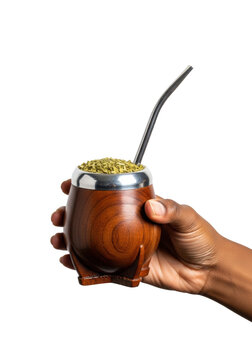 Dark-skinned hand gently cradling a dark wood cuia mate cup filled with steamy green yerba mate and a silver bombilla, macro extreme close-up on transparent, concept of south american tradition