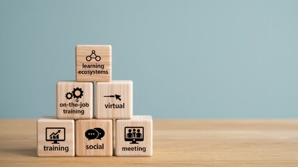 Pyramid stack of wooden blocks detailing modern learning ecosystems training virtual social meeting concepts on a wooden desk with
